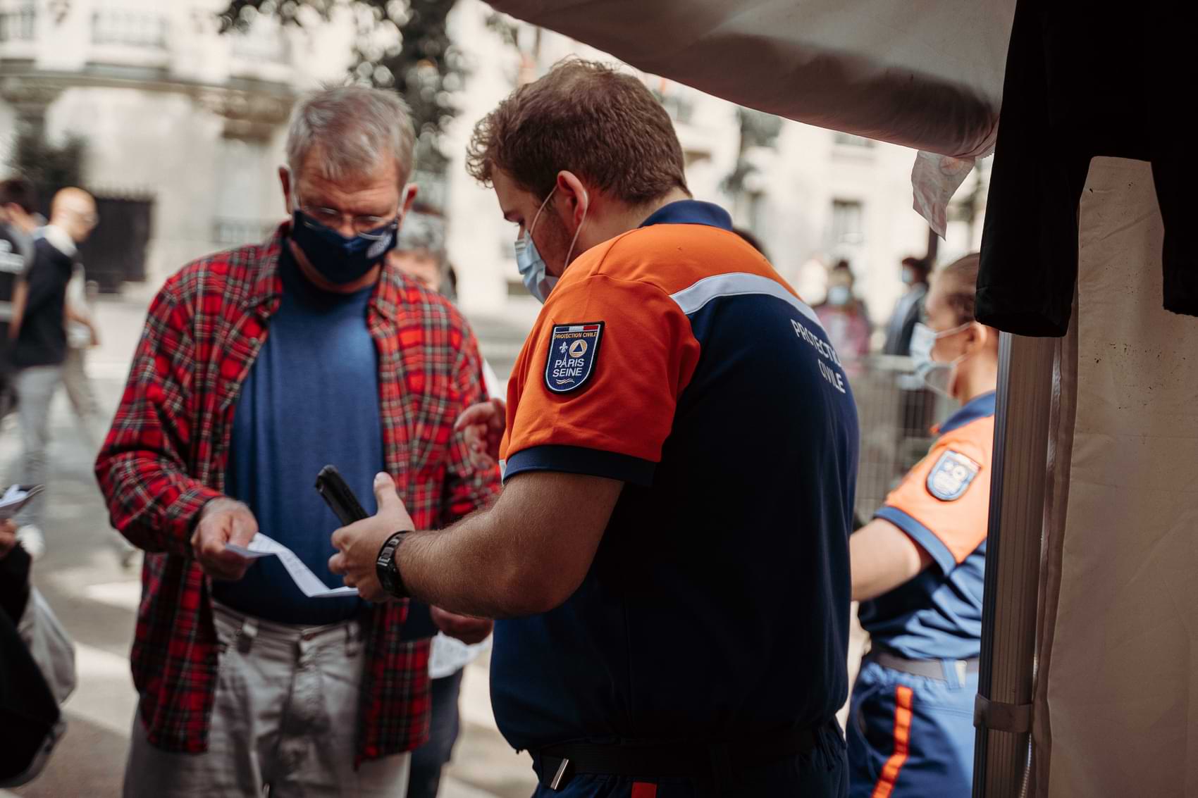 A man gets his vaccine passport scanned before entering a non-essential service