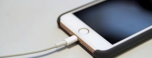 Two iPhones conducting data transfer with a cable.