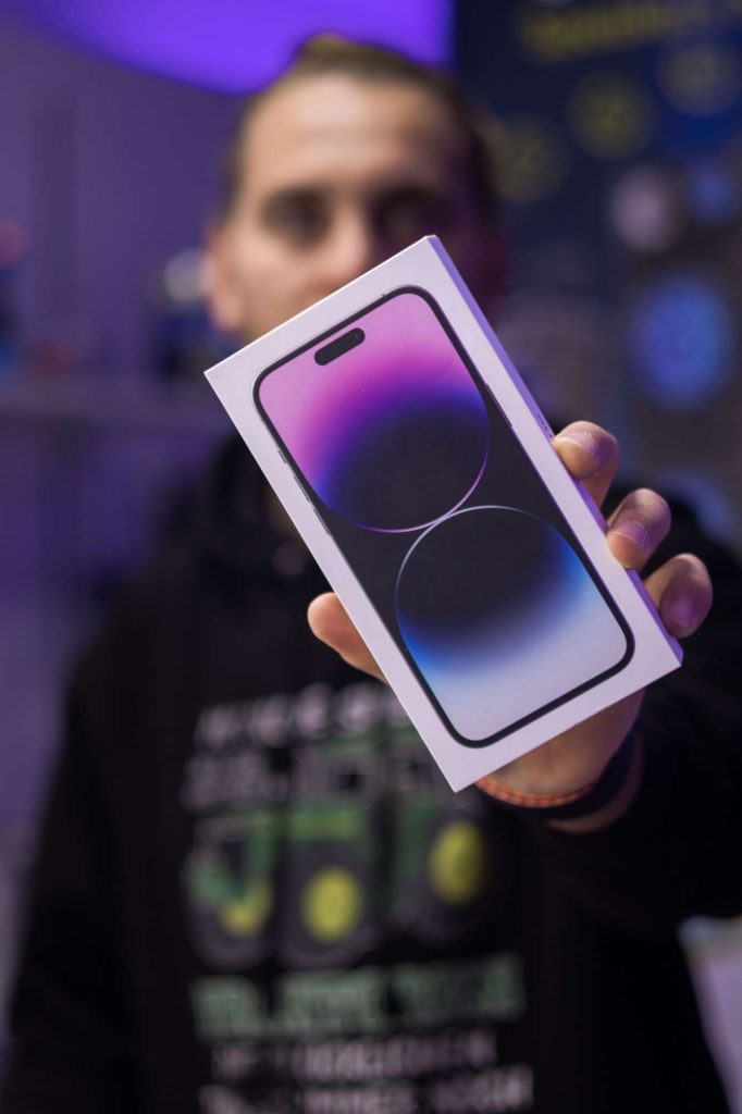 Person holding a new smartphone box inside a store