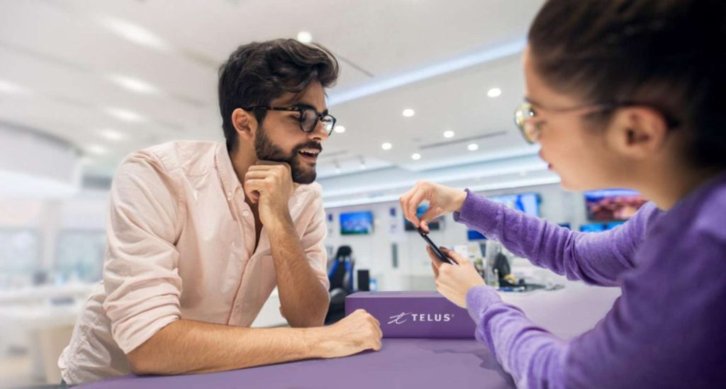 Client consultant un téléphone dans une boutique TELUS