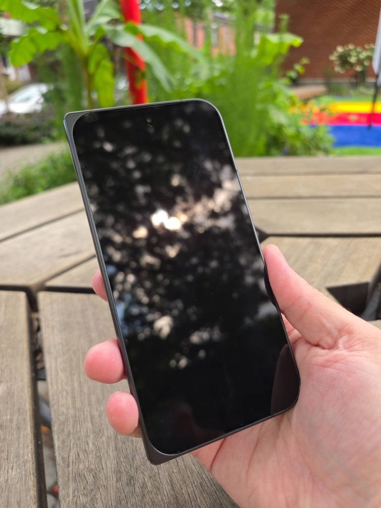 Google Pixel 11 Pro Fold fermé et tenu en main avec l'écran extérieur éteint.