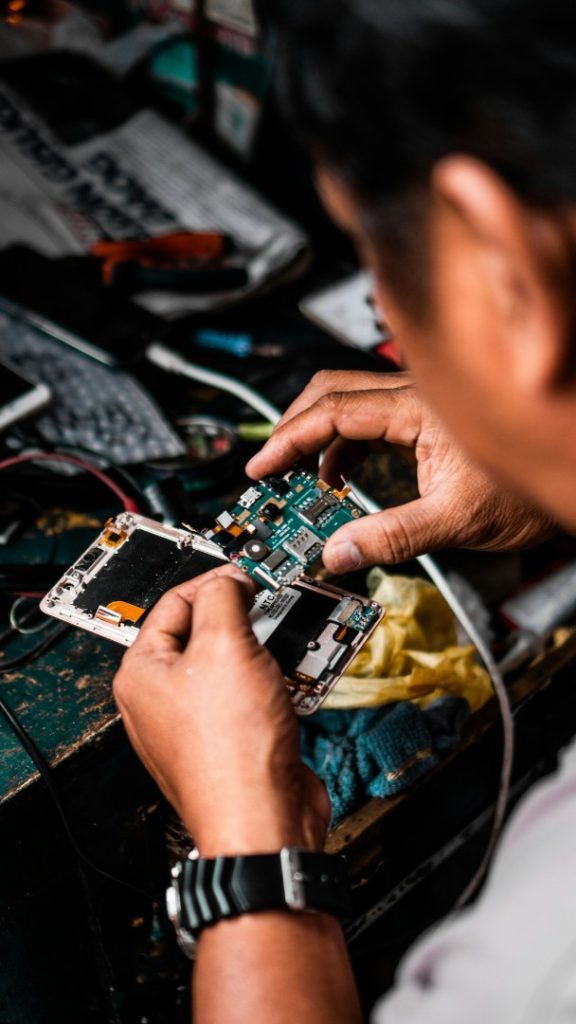 Technician working on smartphone components during a repair