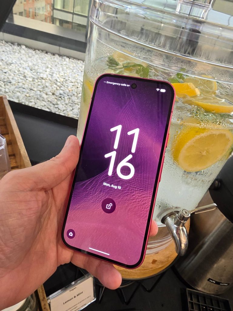 Google Pixel 11 in Hibiscus held in one hand and shown from the back