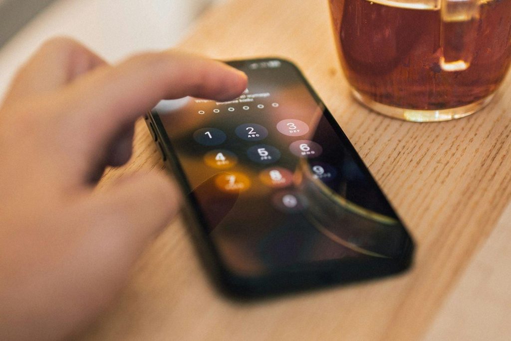 Person unlocking a smartphone to access their device.