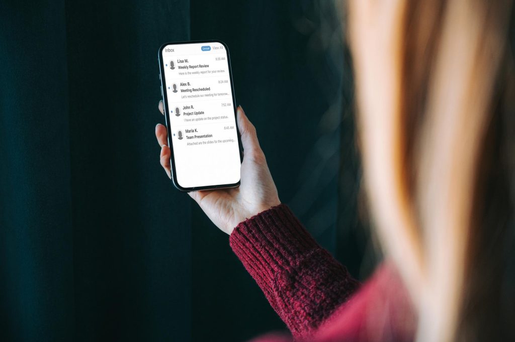 Personne consultant ses courriels sur un téléphone intelligent.